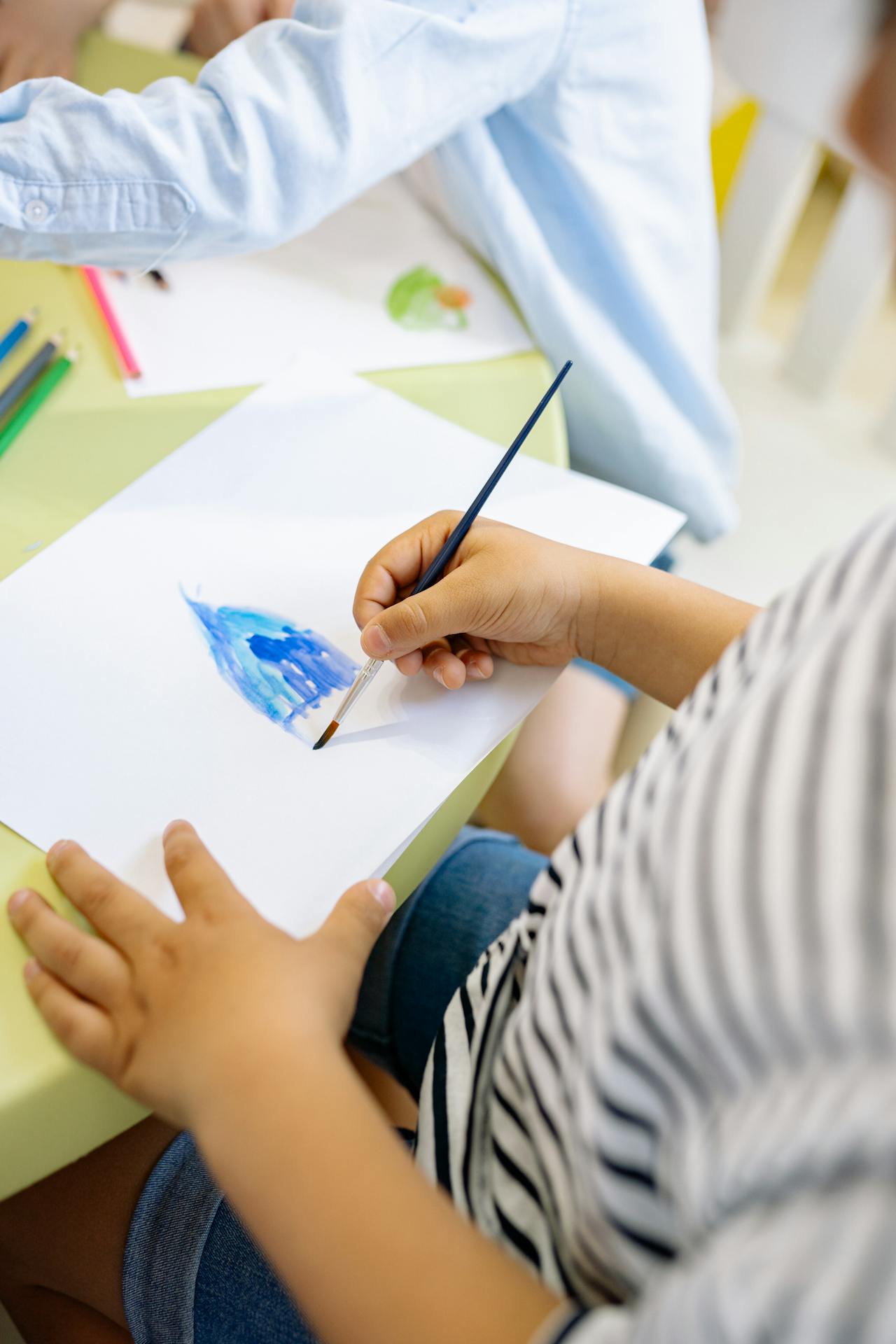 Close-up of child painting with a brush